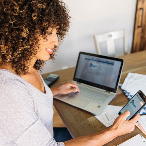 Lawyer looking at a phone and laptop simultaneously to practice lawyer reputation management