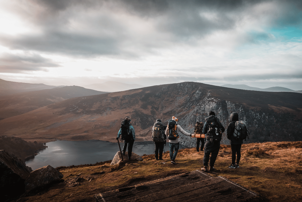 Pearl-Plaza + evo: image of a group of 5 people at the top of a mountain summit with hiking gear on