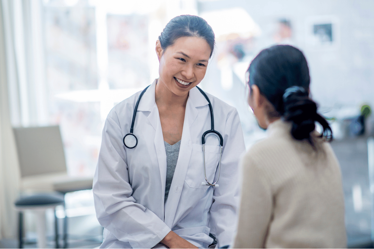 Image of female doctor greeting woman in a clinical setting